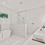 All white tile marble master bathroom open shower free standing tub by Blue Daze Designs, orlando interior design